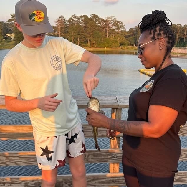 RHF volunteer teaching a youth angler on a South Carolina dock at golden hour